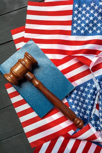 A gavel resting on a stack of legal documents with the US flag in the background, symbolizing legal authority and the enforcement of antitrust laws.