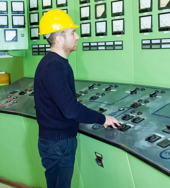A close-up of a technician working on a geothermal power plant control panel, showcasing the advanced technology used in renewable energy production. The panel displays real-time data and system diagnostics.