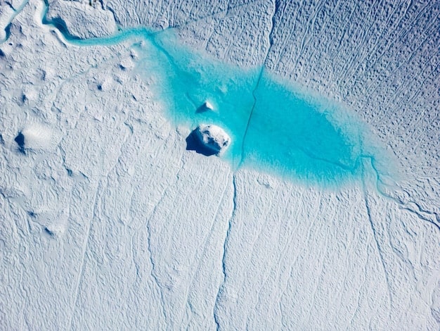 A satellite image of the Arctic region showing the shrinking polar ice cap, overlaid with shipping routes and potential resource extraction zones. National flags of Arctic nations are superimposed on their corresponding territories, indicating competing claims and interests.