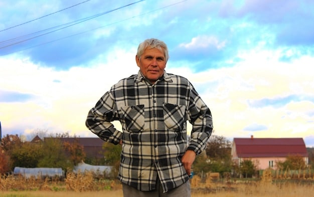 A photograph of older farmers working in a field, showing their weathered faces and the physical demands of their work. The background shows vast farmland, symbolizing the scale of US agriculture.