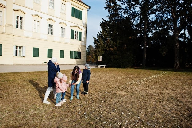A family of four standing in front of a classic American suburban home, symbolizing the lifestyle and opportunities that the EB-5 visa program can provide, including access to education, healthcare, and a stable community.