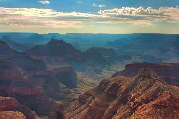 A breathtaking view from the summit of Wheeler Peak in Great Basin National Park, showing sprawling mountain ranges, valleys, and distant desert landscapes under a bright, sunny sky.