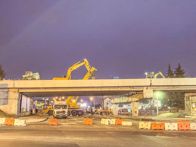 A construction site on a highway, showing workers and heavy machinery involved in road paving and bridge repair. The scene highlights the modernization and upgrade of road infrastructure.