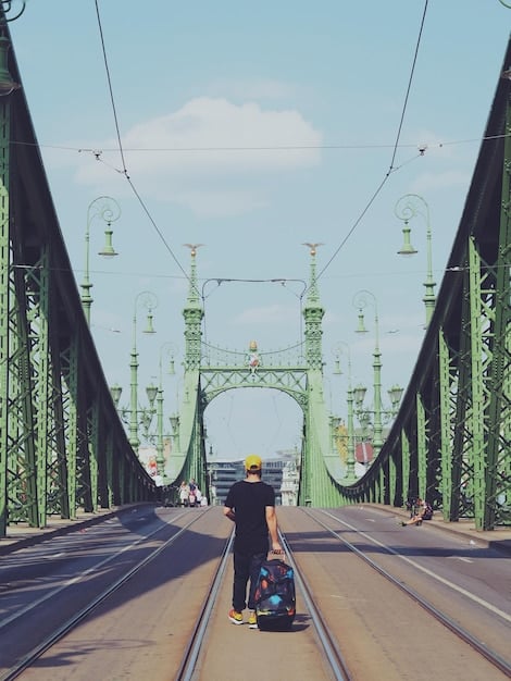 A view of the accessible pathway along the Golden Gate Bridge in San Francisco, with a traveler in a wheelchair enjoying the iconic scenery. The pathway is smooth and well-maintained.